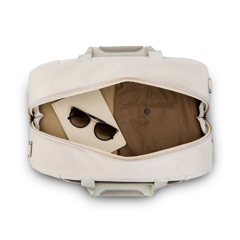 Open beige weekender showing inner compartments and clothing