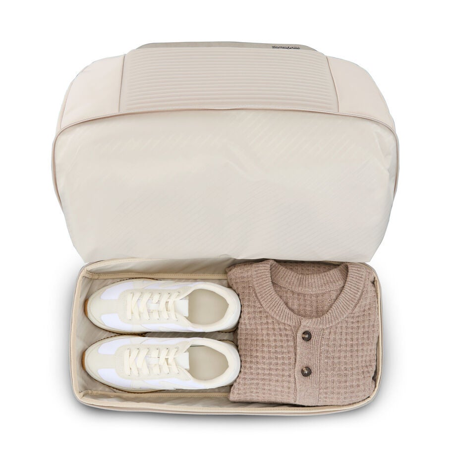 Top view of weekender with pair of shoes and sweater inside